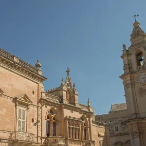 Baroque building facade with clock tower and windows against a clear sky