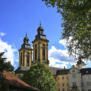 Églises baroques avec deux sommets et des arbres environnants dans une ville historique.