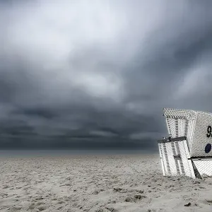 Beach chair in front of dark cloudy sky Beach chair in front of dark cloudy sky