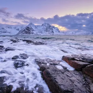 Beach of Norwegian sea on rocky coast in fjord on sunset in winter Beach of Norwegian sea on rocky coast in fjord on sunset in winter