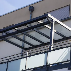 Beautiful balcony roofing made of glass and aluminium on a residential building