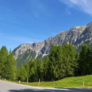 Beautiful Mountain Road in a Mountain Valley in the Swiss Alps in a Sunny Summer Day with Blue Sky and Clouds in Albula Beautiful Mountain Road in a Mountain Valley in the Swiss Alps in a Sunny Summer Day with Blue Sky and Clouds in Albula
