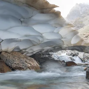 The beautiful view of frozen glacier and Kaznok river neat to Zmeya peak in Fann mountains in Tajikistan