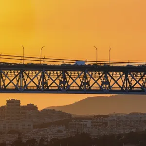 Beautiful view of golden sunset and suspension city bridge with its steel structure and cables