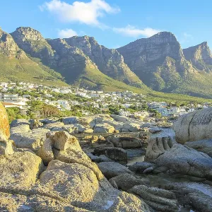 Big rocks in Camps Bay with Table Mountain National Park behind him Big rocks in Camps Bay with Table Mountain National Park behind him