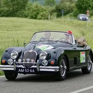 Black convertible driving on a country road through an idyllic landscape Black convertible driving on a country road through an idyllic landscape