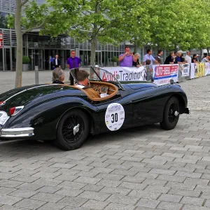 Black vintage convertible on event street with spectators