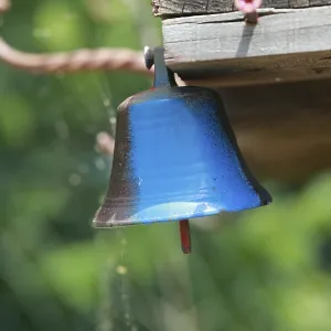 Blue bell hanging from a wooden post Blue bell hanging from a wooden post