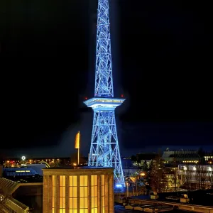 Blue-lit Berlin radio tower, steel half-timbered building by architect Heinrich Straumer