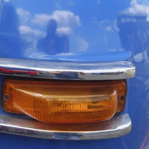 Blue vintage car with orange tail light and chrome accents