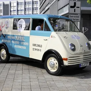Blue and white vintage van with advertising lettering and number 74 on cobblestones Blue and white vintage van with advertising lettering and number 74 on cobblestones