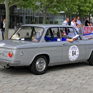 BMW, gray four-door classic car at a car event on cobblestones