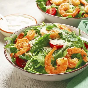 Two bowls of shrimp salad, arugula and cherry tomatoes