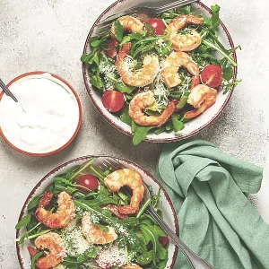 Two bowls of shrimp salad, arugula and cherry tomatoes