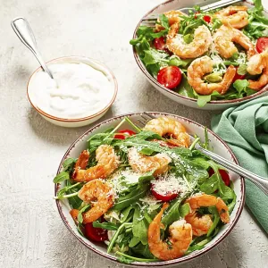 Two bowls of shrimp salad, arugula and cherry tomatoes
