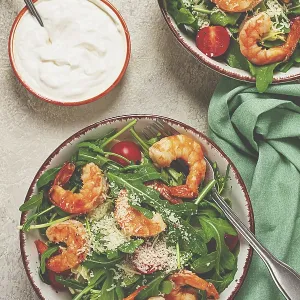Two bowls of shrimp salad, arugula and cherry tomatoes