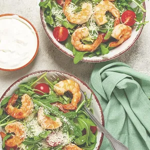 Two bowls of shrimp salad, arugula and cherry tomatoes