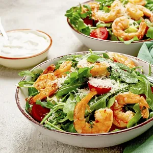 Two bowls of shrimp salad, arugula and cherry tomatoes