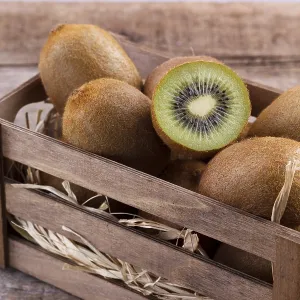 Box of fresh kiwi in on wooden background Box of fresh kiwi in on wooden background
