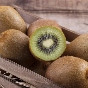 Box of fresh kiwi in on wooden background Box of fresh kiwi in on wooden background