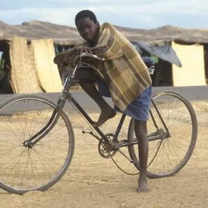 Boy with bicycle in front of a street market Boy with bicycle in front of a street market