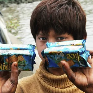 Boy showing oil soaked biscuit packets due to container ship chitra colliding in sea Mumbai Boy showing oil soaked biscuit packets due to container ship chitra colliding in sea Mumbai