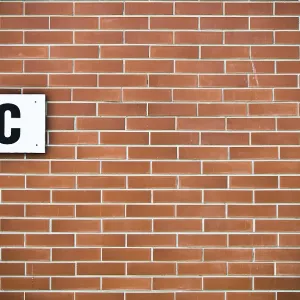 A brick wall with a WC sign mounted on it