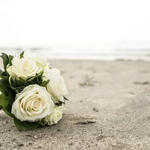 Bridal bouquet of white roses lying on a North Sea beach