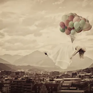 Bride floating on balloons over Innsbruck
