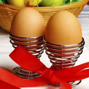 Brown eggs in metal holders with a red ribbon Brown eggs in metal holders with a red ribbon
