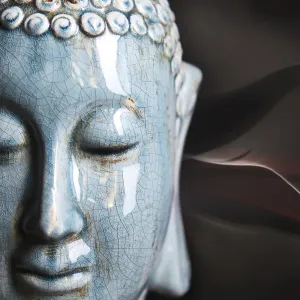 Buddha close up portrait over dark background Buddha close up portrait over dark background