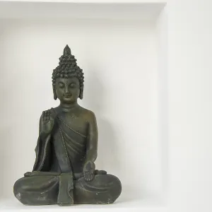 A buddha figure with in a recession on a white wall A buddha figure with in a recession on a white wall