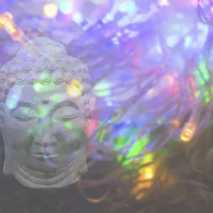 Buddha head on colourful psychedelic light background copy space