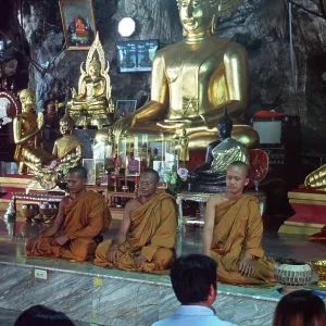 Buddha statue, monks and believers praying Buddha statue, monks and believers praying