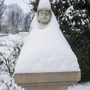 Buddha statue on a pillar has put on a snow coat Buddha statue on a pillar has put on a snow coat