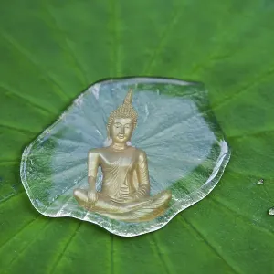 Buddha statue reflected in a drop of water on a lotus leaf Buddha statue reflected in a drop of water on a lotus leaf