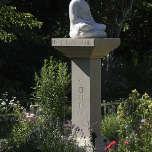 Buddha statue on a stone pillar in the garden Buddha statue on a stone pillar in the garden
