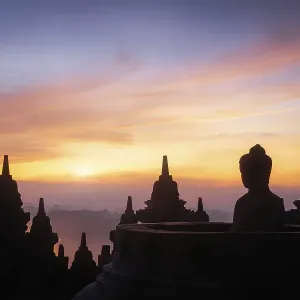Buddha statue at sunrise, Borobudur temple complex Buddha statue at sunrise, Borobudur temple complex