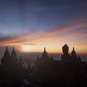 Buddha statue at sunrise, Borobudur temple complex Buddha statue at sunrise, Borobudur temple complex