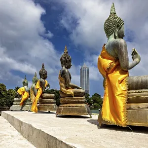 Buddha statues on the water with yellow robes against an urban backdrop Buddha statues on the water with yellow robes against an urban backdrop