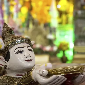 Buddhist angel holding a bowl of coins