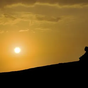 Buddhist meditating at sunset
