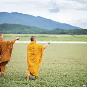 Two Buddhist monks in the dry lake bed at Doi Tao