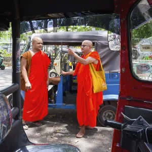 Buddhist monks talking near a tuk-tuk Buddhist monks talking near a tuk-tuk