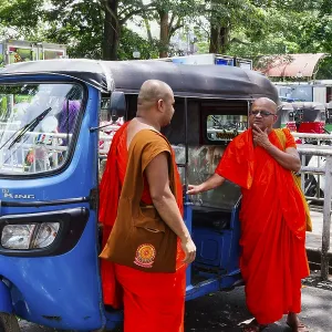 Buddhist monks talking near a tuk-tuk Buddhist monks talking near a tuk-tuk