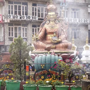 Buddhist statue in an urban setting with religious symbols and plants Buddhist statue in an urban setting with religious symbols and plants