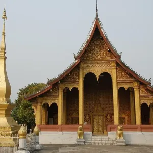 Buddhist Temple in gold and dark red next to a small gold stupa Buddhist Temple in gold and dark red next to a small gold stupa