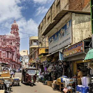 Bustling market street with people and stalls