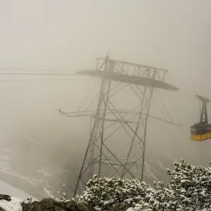 Cable car technicians working in bad weather conditions Cable car technicians working in bad weather conditions