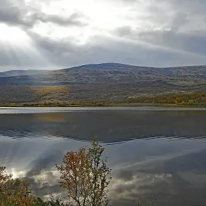 A calm lake with mountains in the background A calm lake with mountains in the background